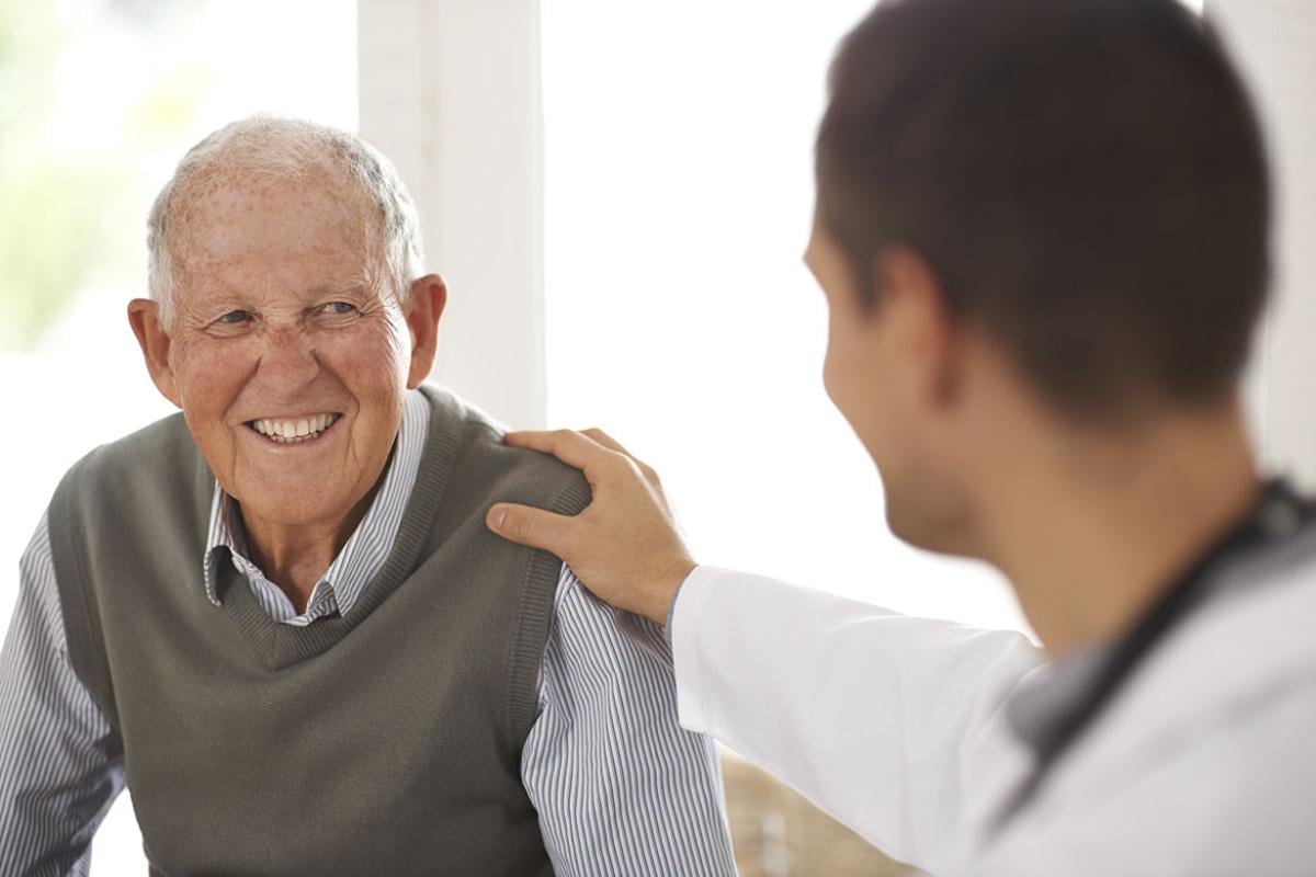 Doctor with a hand on a smiling patient's shoulder