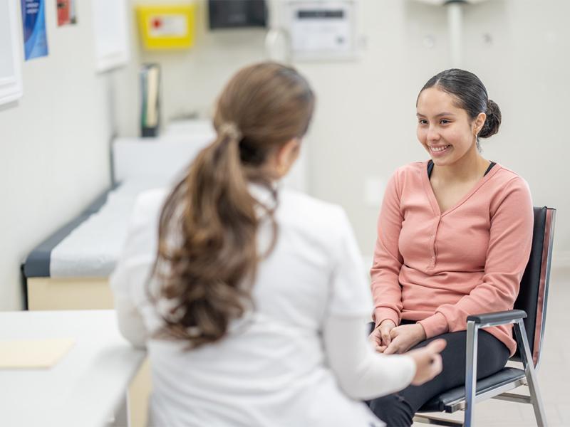 Medical student talking to smiling patient