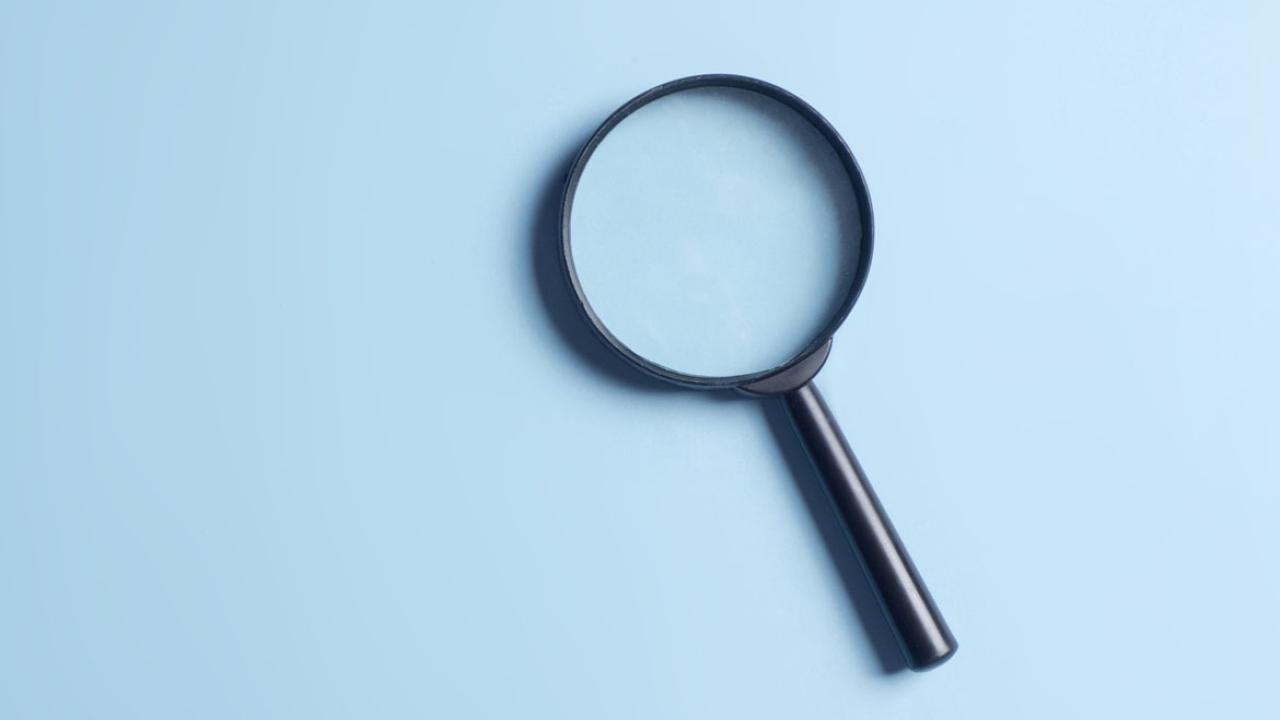Magnifying glass on a light blue background.