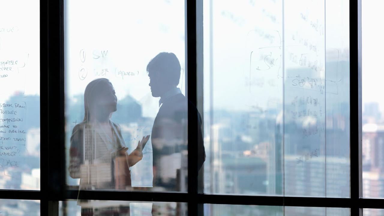 Two people speaking in a conference room