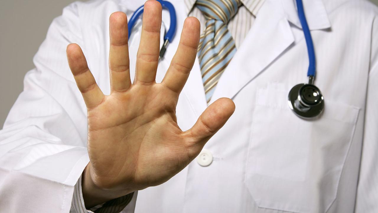 Male physician with his hand facing out in "stop" gesture