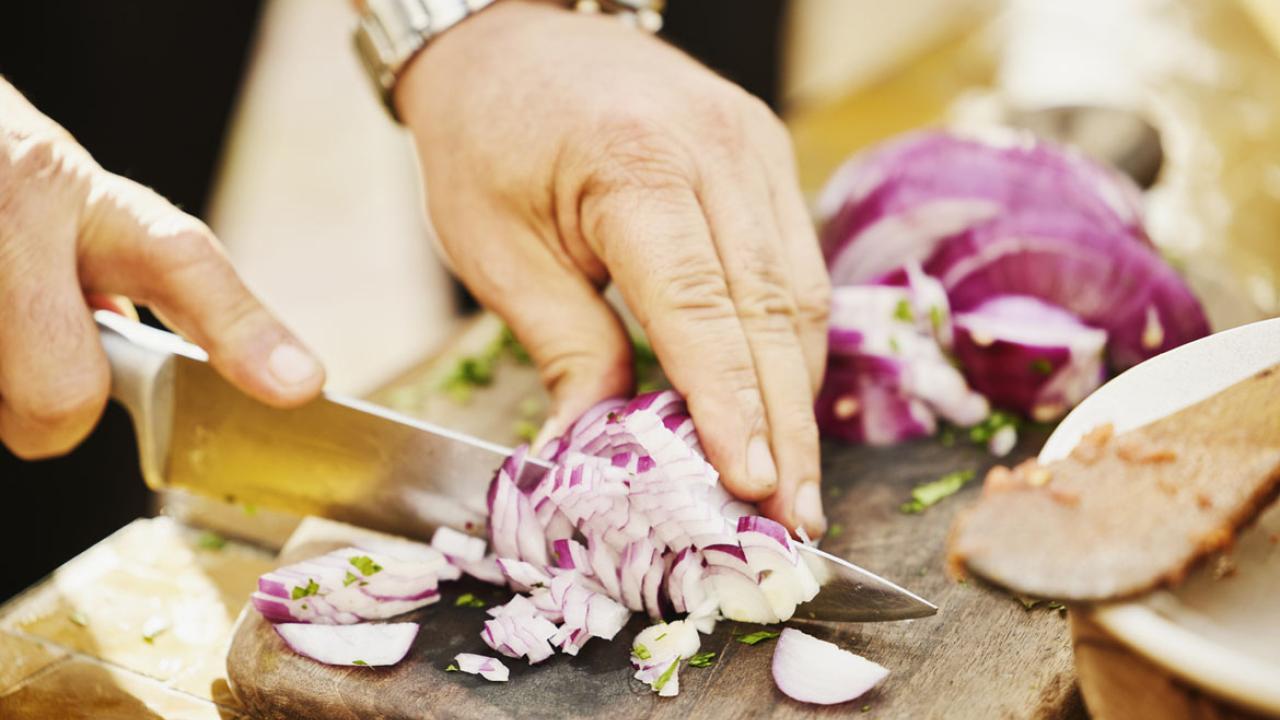Hands cutting an onion