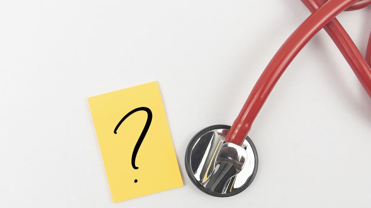 Paper with a question mark next to a stethoscope