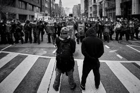 Two figures standing in front of law enforcement officers