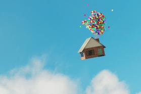  House floating in the air with a bunch of colorful balloons tied together coming out of its chimney