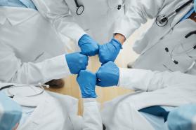 Group of health care workers bumping gloved fists