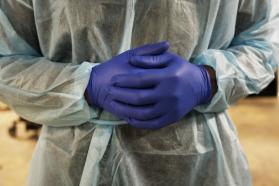 Midsection of a health care worker with gloved hands