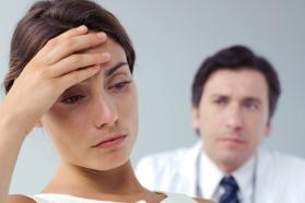 Patient in discomfort with physician looking on. 