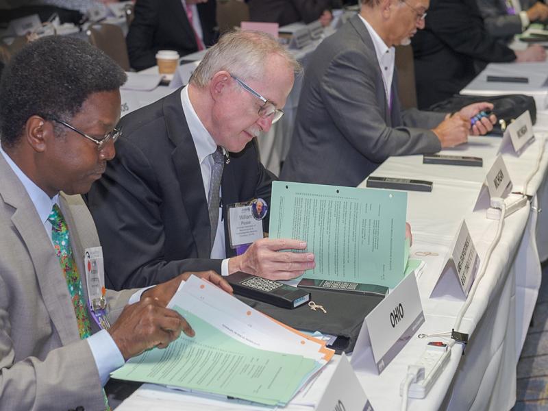 Members reading reports at the Annual Meeting