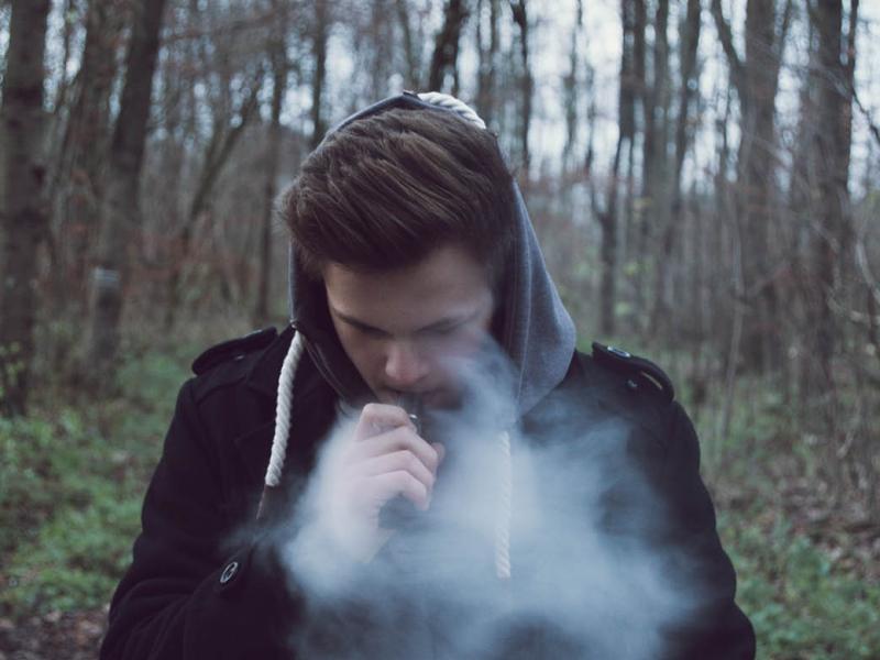 Teenager smoking an e-cigarette