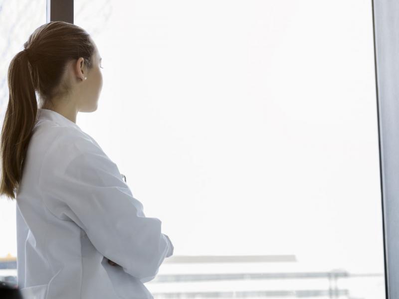 Woman physician looking out the window