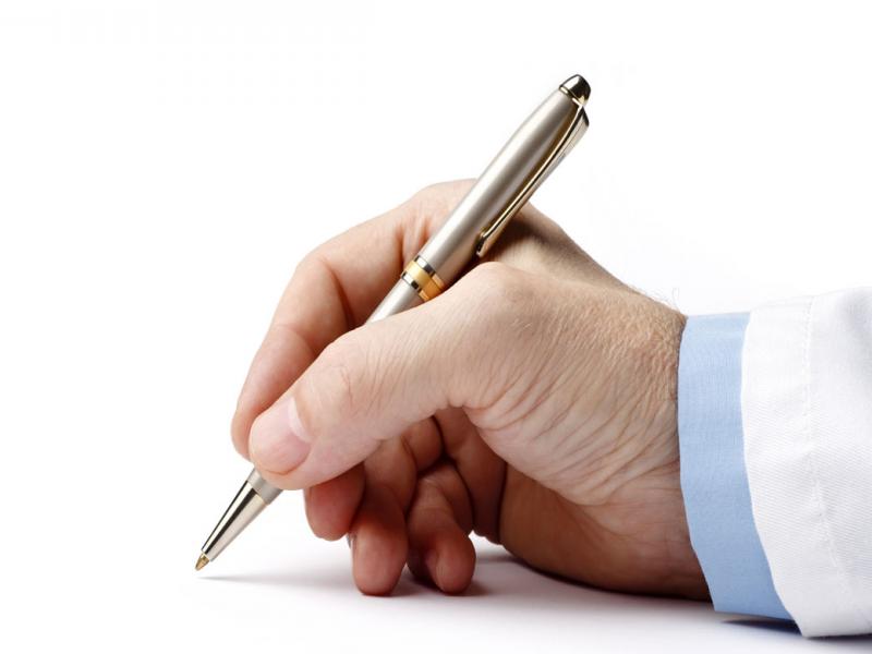 Close-up of a man signing with a pen