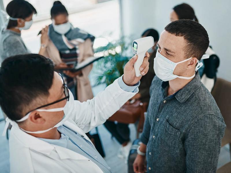 Health care worker taking patient's temperature
