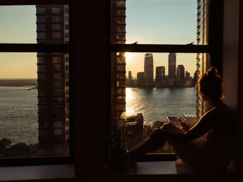 Person looking out window to a cityscape