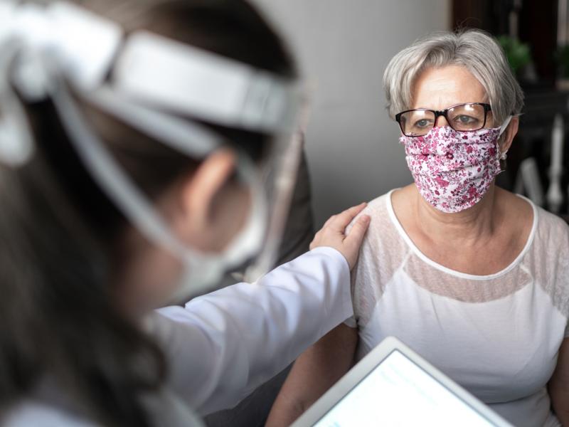 Patient in face mask with health care professional