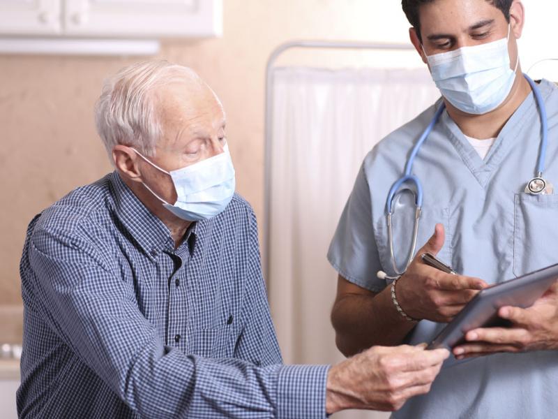 Patient and health care worker looking at a tablet.