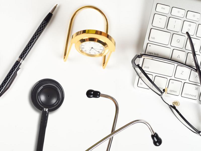 Keyboard, glasses and stethoscope on a desk