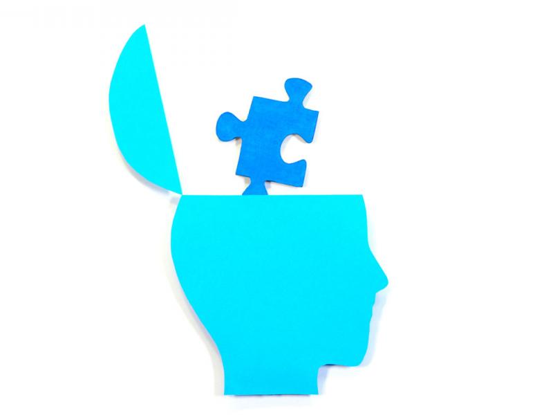 Puzzle piece coming out of human brain.