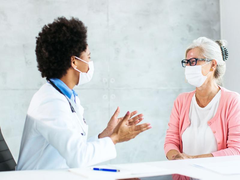 Patient and health care worker smiling behind face masks