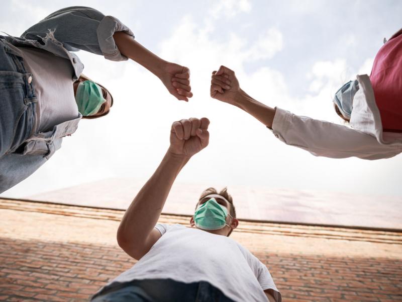 Three people fist bumping