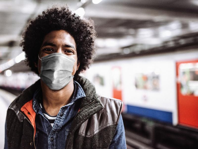 Person wearing a face mask in a train station
