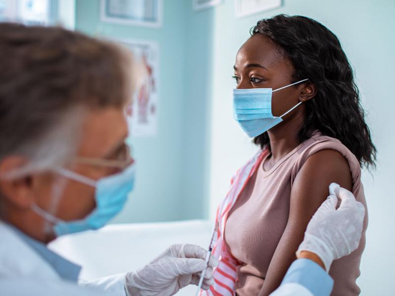 Physician prepping to administer vaccine to patient