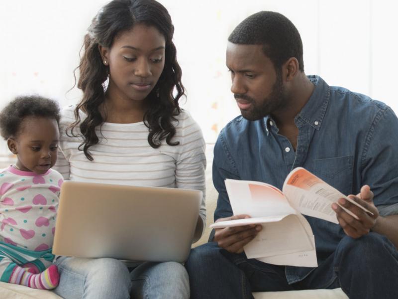 Family looking at a laptop and bills