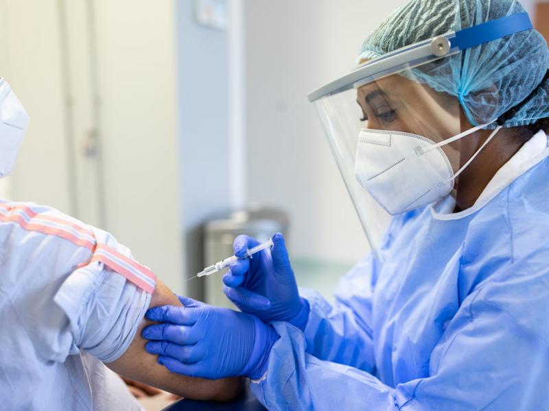 Health care worker administering vaccine