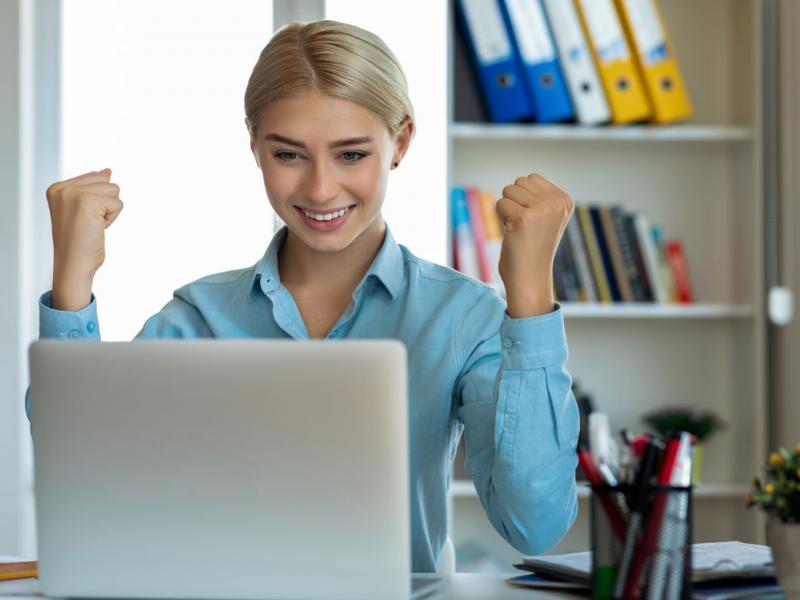 Smiling person looking at a laptop