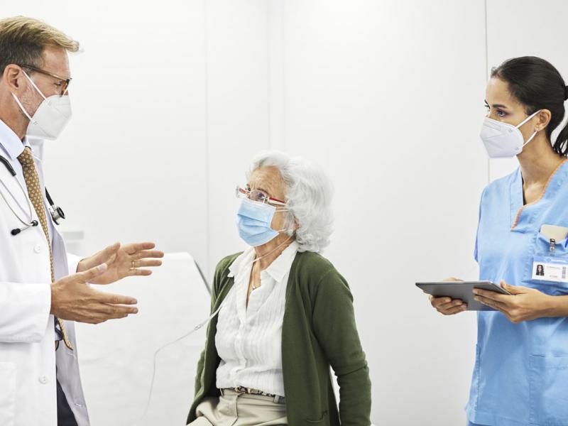 Health care workers speaking with patient