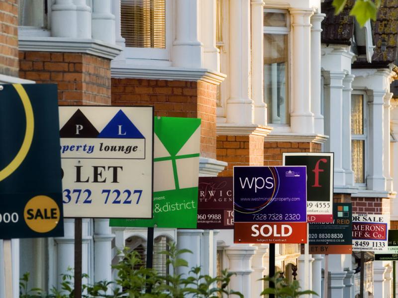For sale signs in front of a row of houses