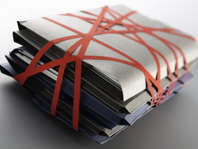 Stack of files wrapped up with red tape