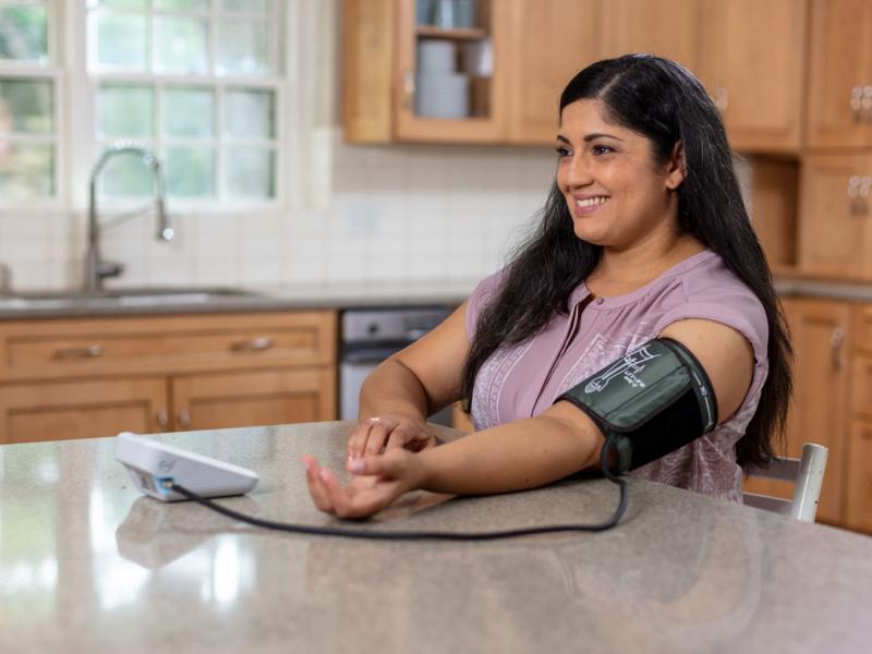 Smiling person measuring blood pressure