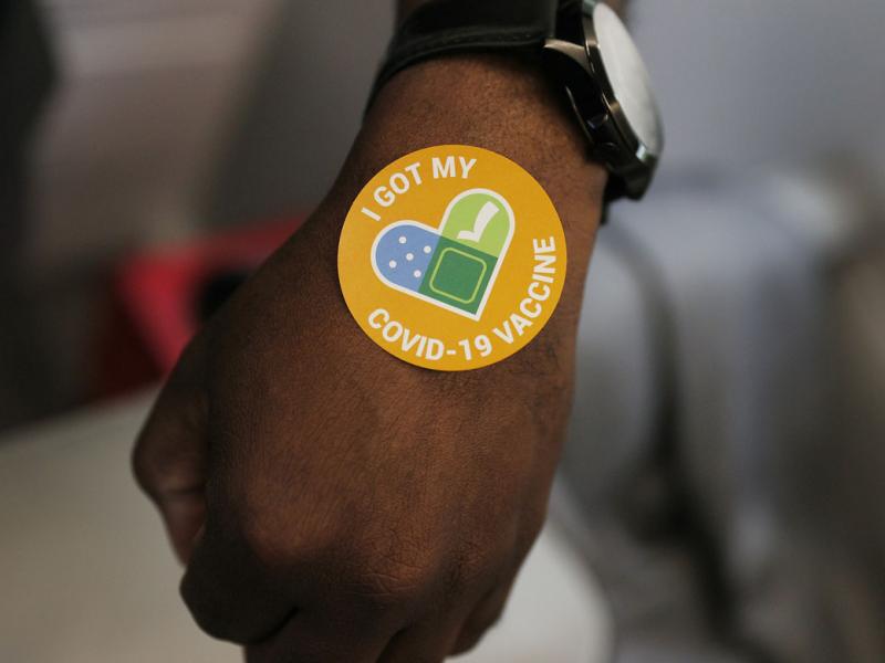 Hand with a sticker saying that they received a vaccine
