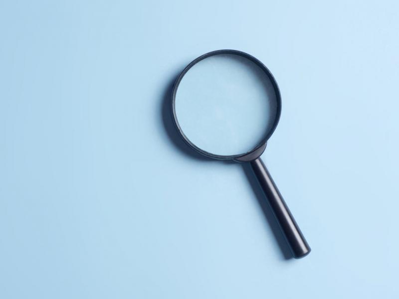 Magnifying glass on a light blue background.