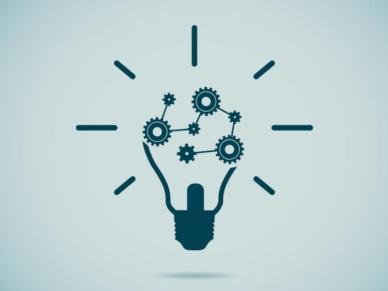 Illustration of a dark grey lightbulb, with the inner workings replaced by a series of gears.