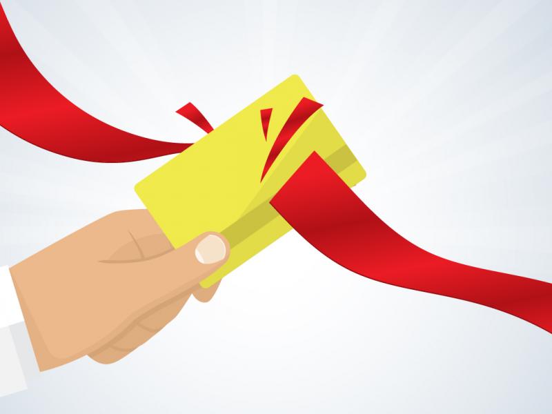 Illustration of a gold card with a red ribbon or tape slicing through it.