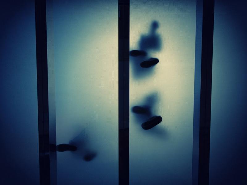 Feet seen through transparent glass panels