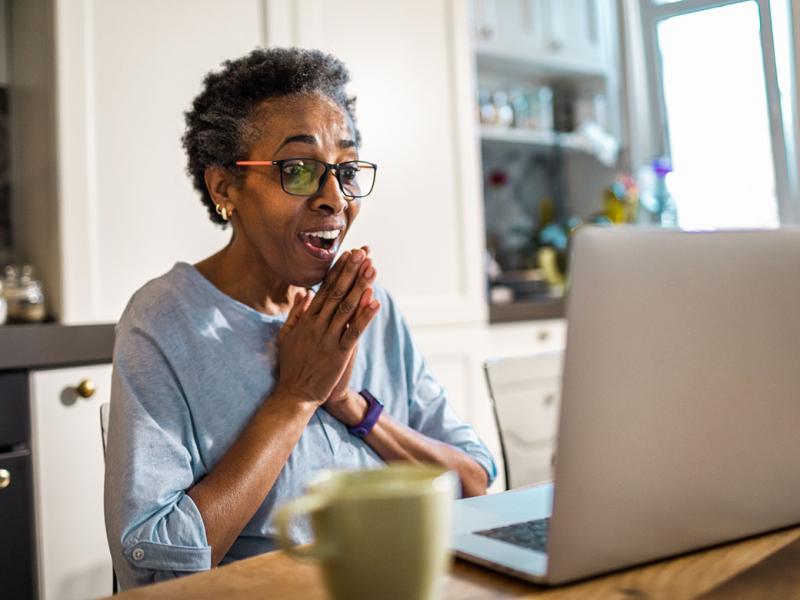 Smiling person in front of a laptop