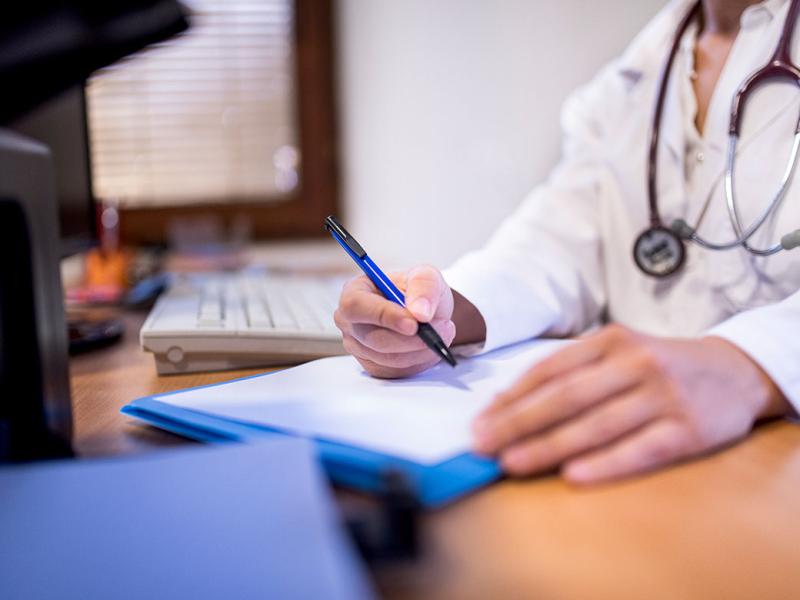 Physician signing a form