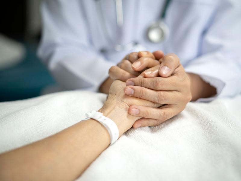 Physician holding patient's hand