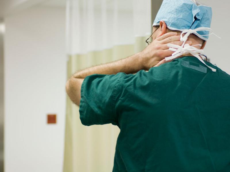 Health care professional rubbing back of neck