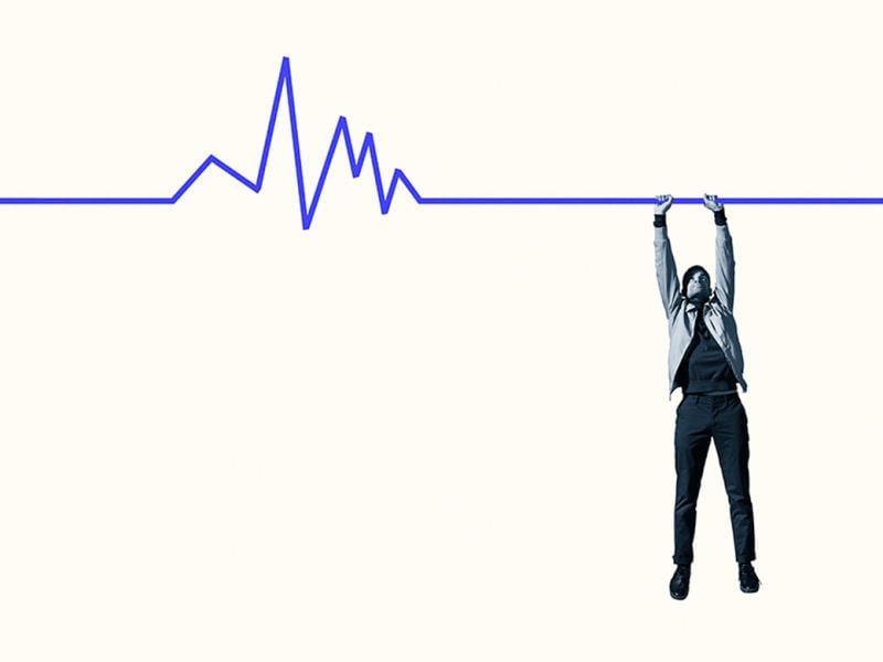 Person hanging from blue line graph 