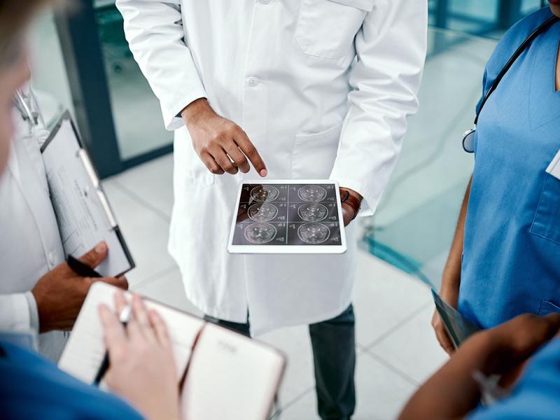Group of health care professionals looking at a tablet