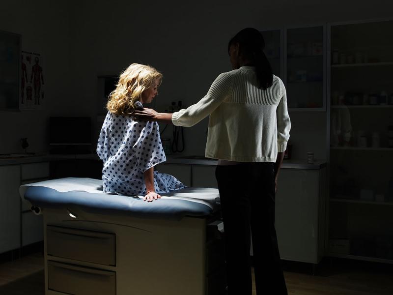 Health care worker and patient in a dimly lit room