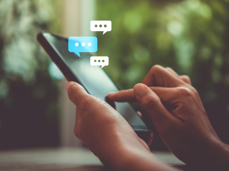 Person using mobile phone with speech bubbles
