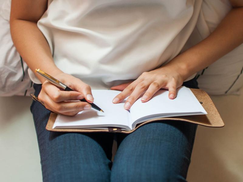 Someone about to write on an empty journal