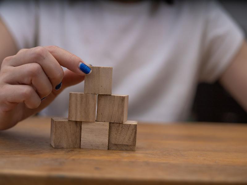 Person stacking blocks on table