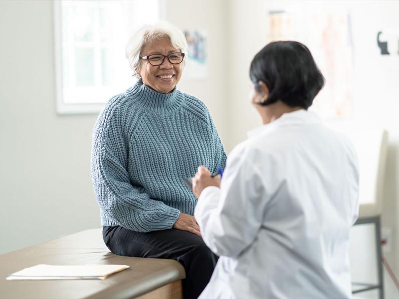 Smiling person speaking with physician