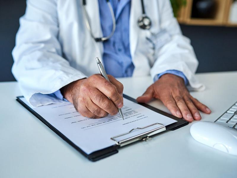 Doctor writing on a form